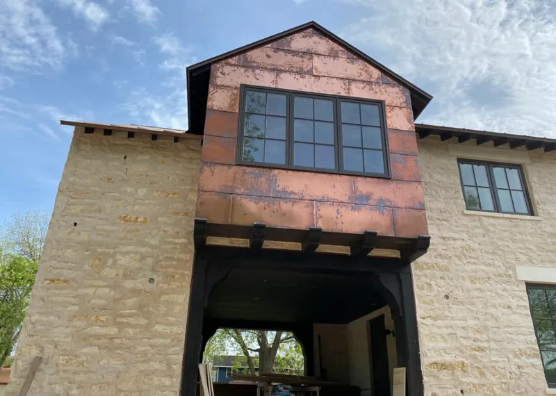 Copper metal panel facade on a stone building for Roof Repair in Glassmanor