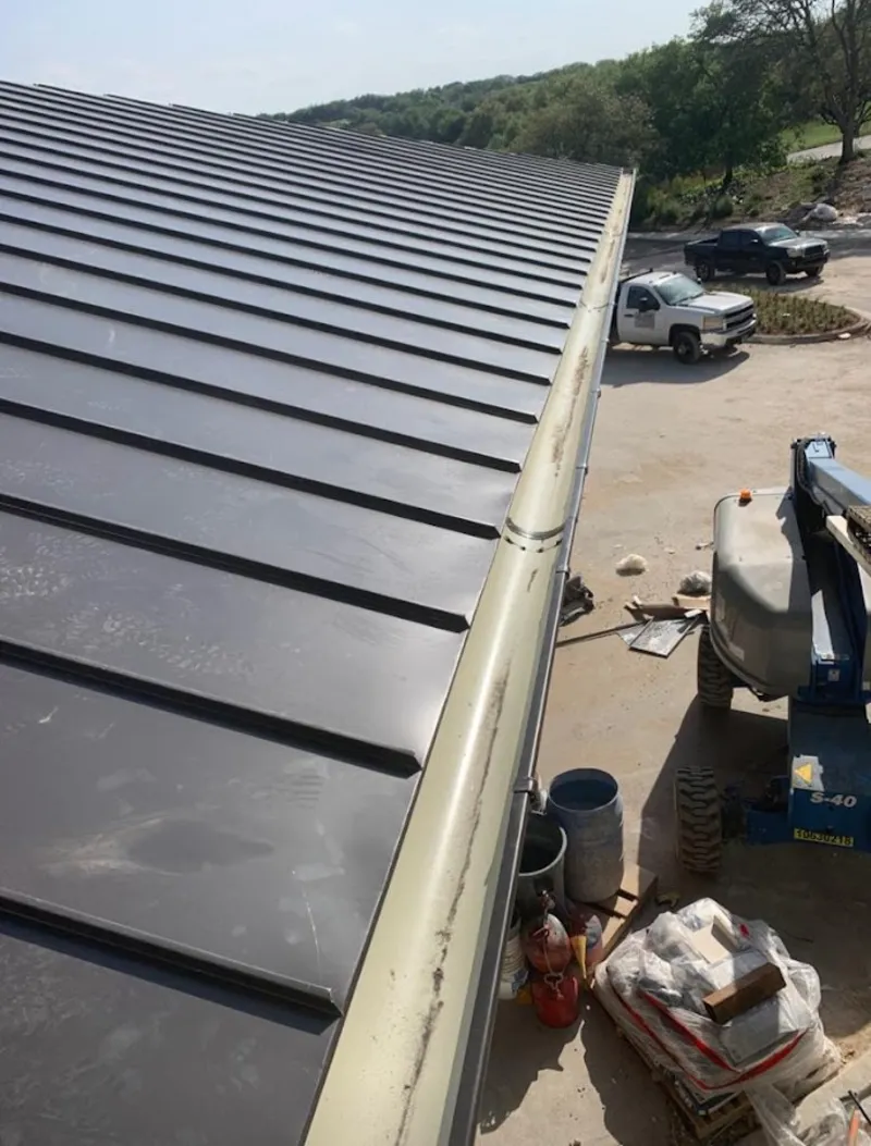 Standing seam panel and gutter detail on a metal roofing jobsite in Glassmanor